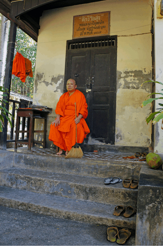 monk in chiang mai siting in front of a door