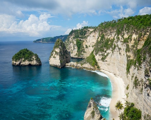 Pristine coastal cliff landscape with turquoise waters and lush green foliage, ideal for Exclusivetravelbooking123 adventures.