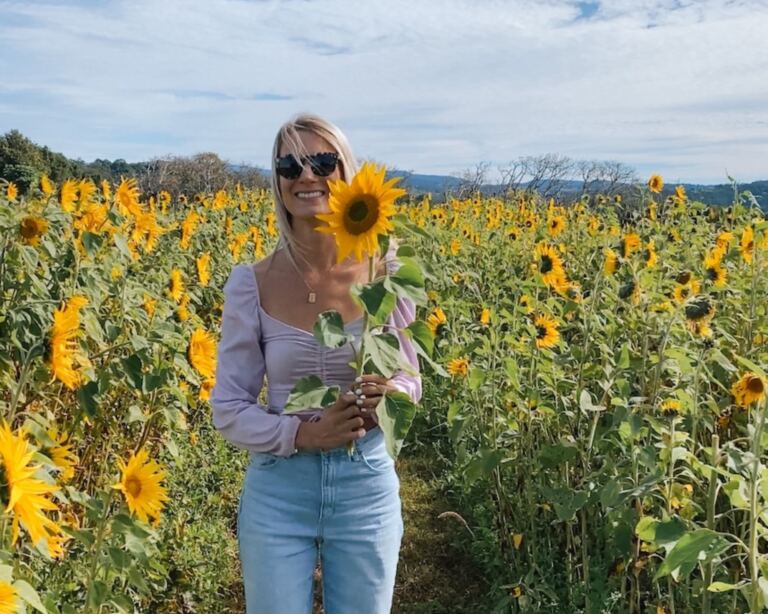 Bright woman enjoying a sunflower field, perfect for travel and outdoor adventures.