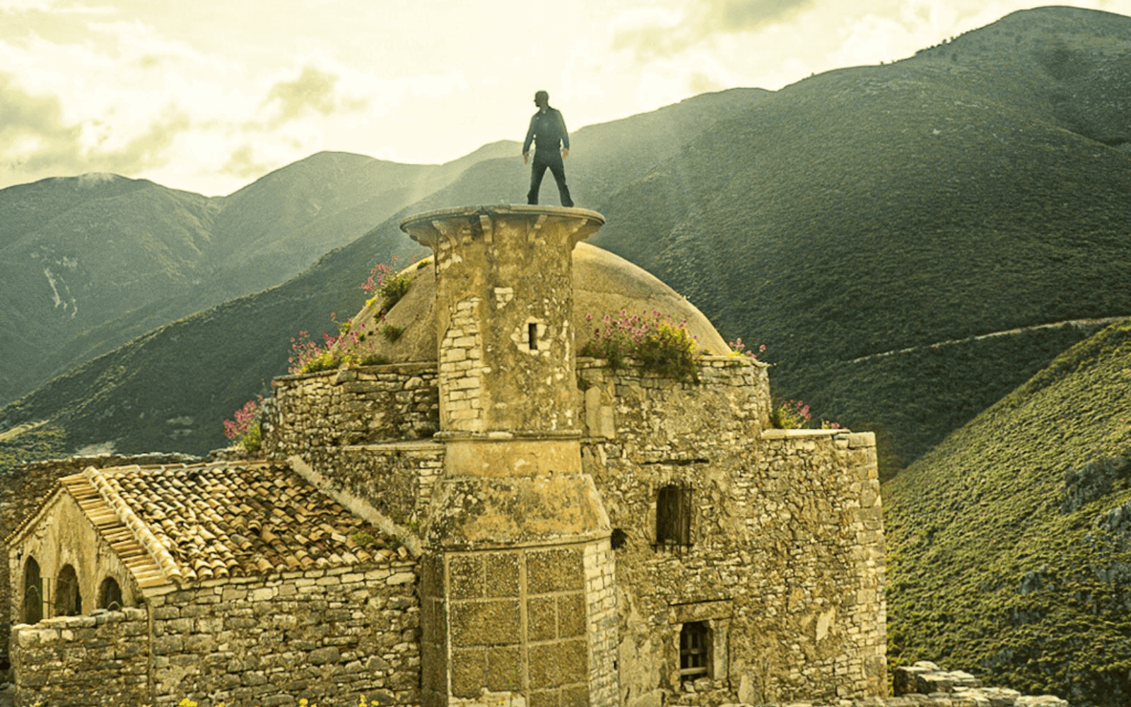 Man standing on ruins of old mosque with mountains in the background at Borsh Castle-Photo by Abby Davis