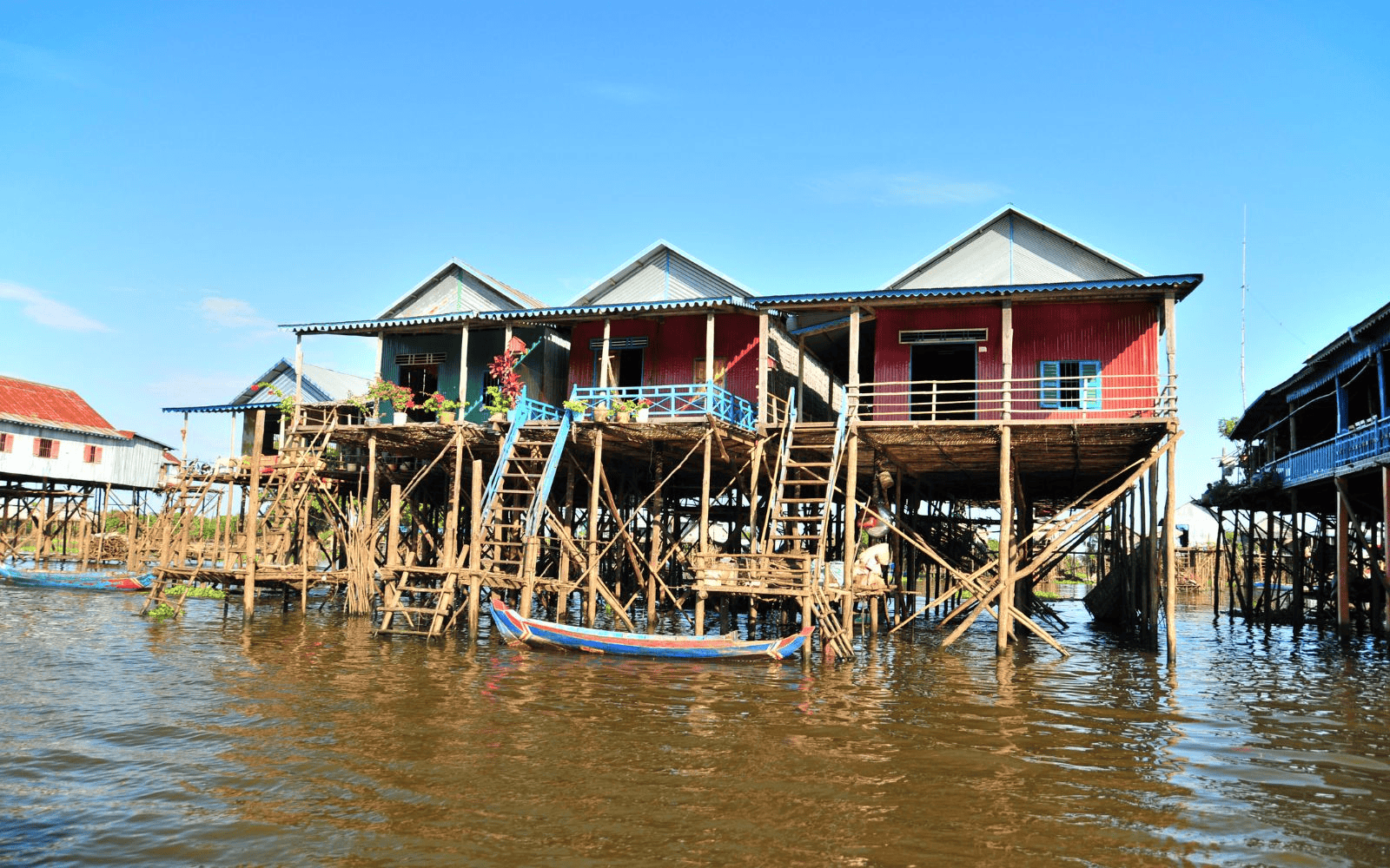 Houses on stilts in the floating villages at Tonlé Sap Lake with boat out front