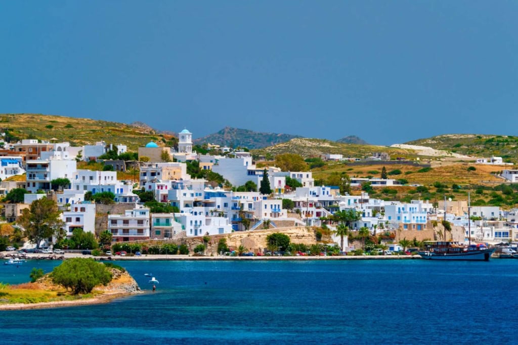 Colorful Greek island village with white buildings and blue sea scenery for travel inspiration.
