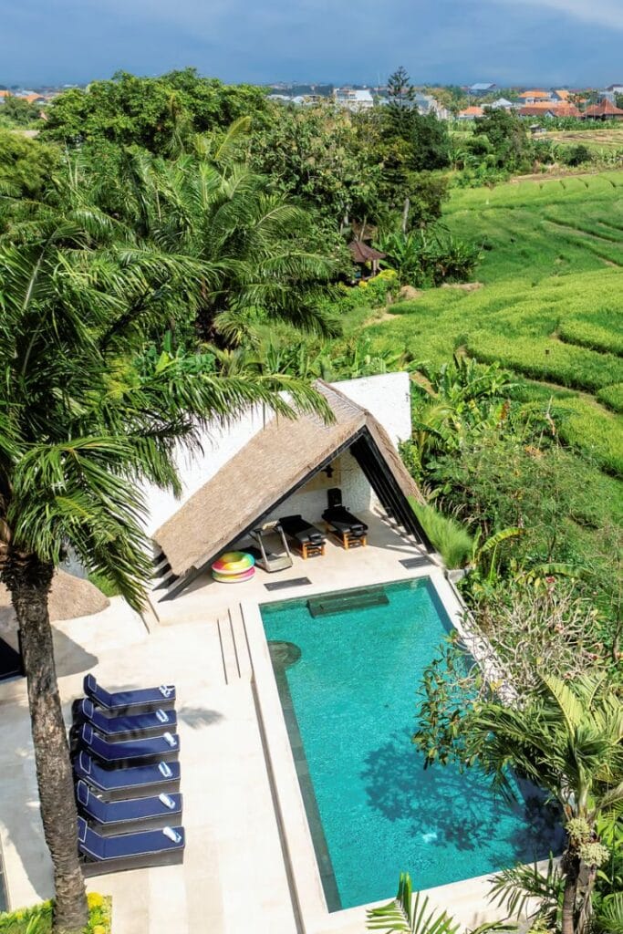 Luxurious tropical villa with private pool surrounded by lush greenery and scenic countryside views.