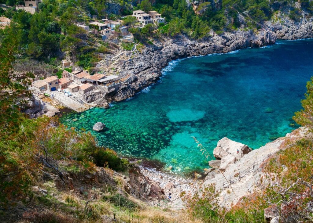 aerial view of gorgeous rock formations and crystal clear waters at Cala de Deia Beach