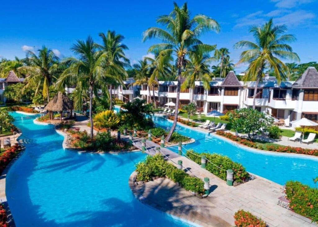 Swimming pool at Sheraton Denarau Villas with palm trees and hotel