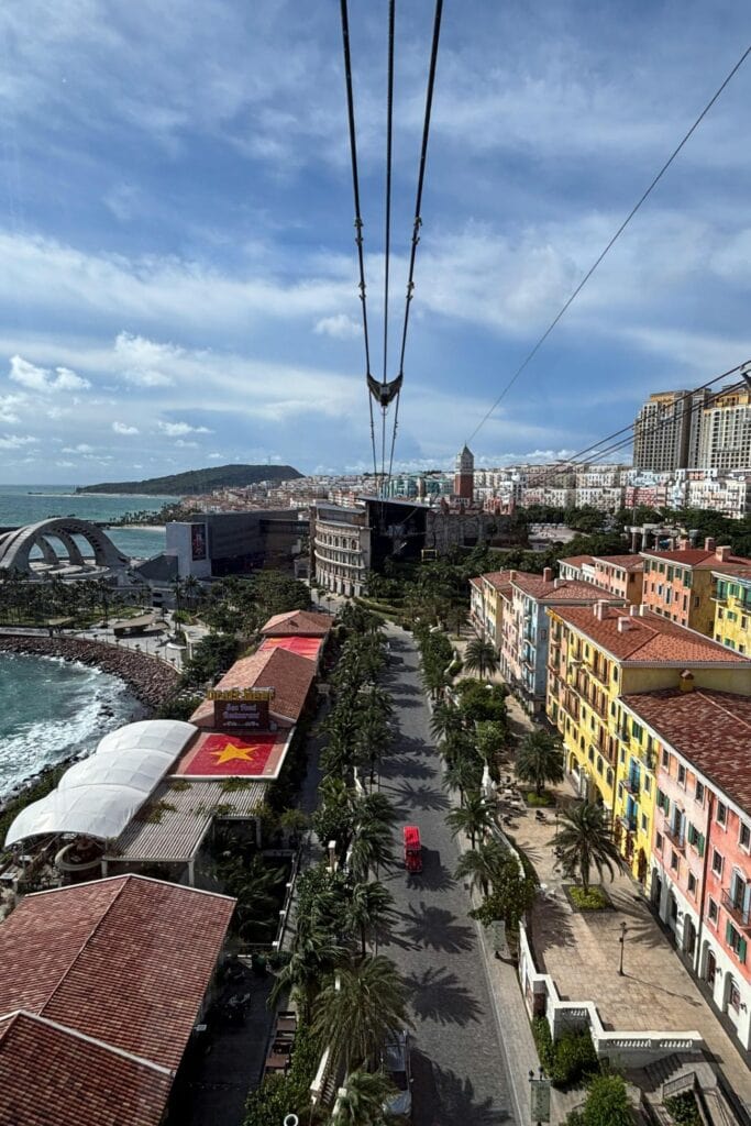 Cable car over Phu Quoc city with colorful buildings and coastline.