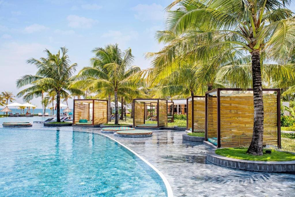 Beautiful pool area with palm trees on Phu Quoc island, perfect for relaxing by the beach.