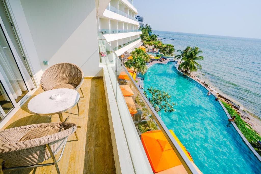 Balcony view of Phu Quoc beach and pool at a seaside hotel.
