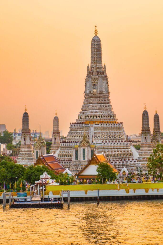 Intricate temple in Bangkok at sunset, showcasing Thai architecture and cultural heritage.