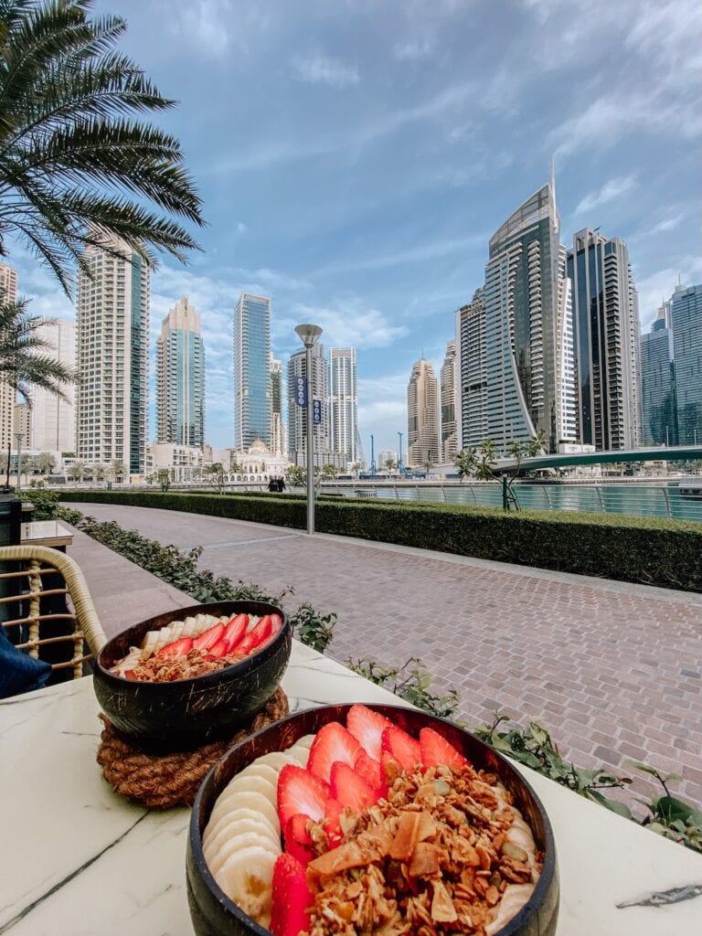 Vibrant cityscape with modern skyscrapers and a waterfront view, promoting travel to Dubai.