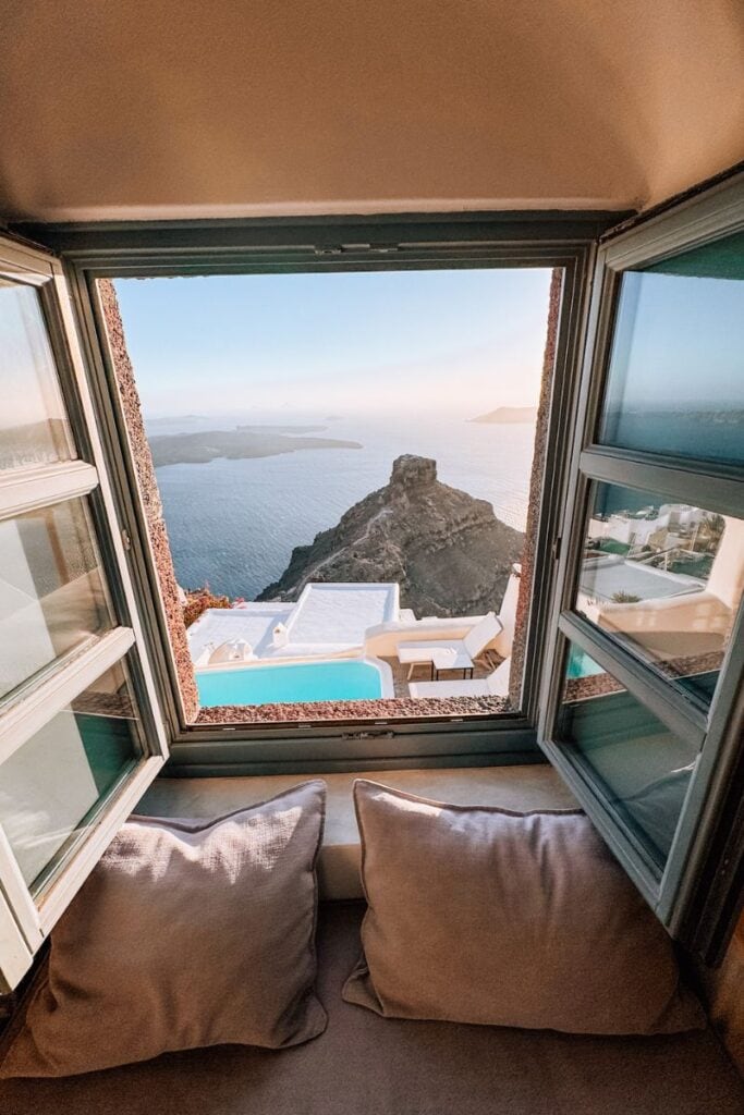 Stunning ocean view from Santorini hotel with infinity pool and natural landscape.