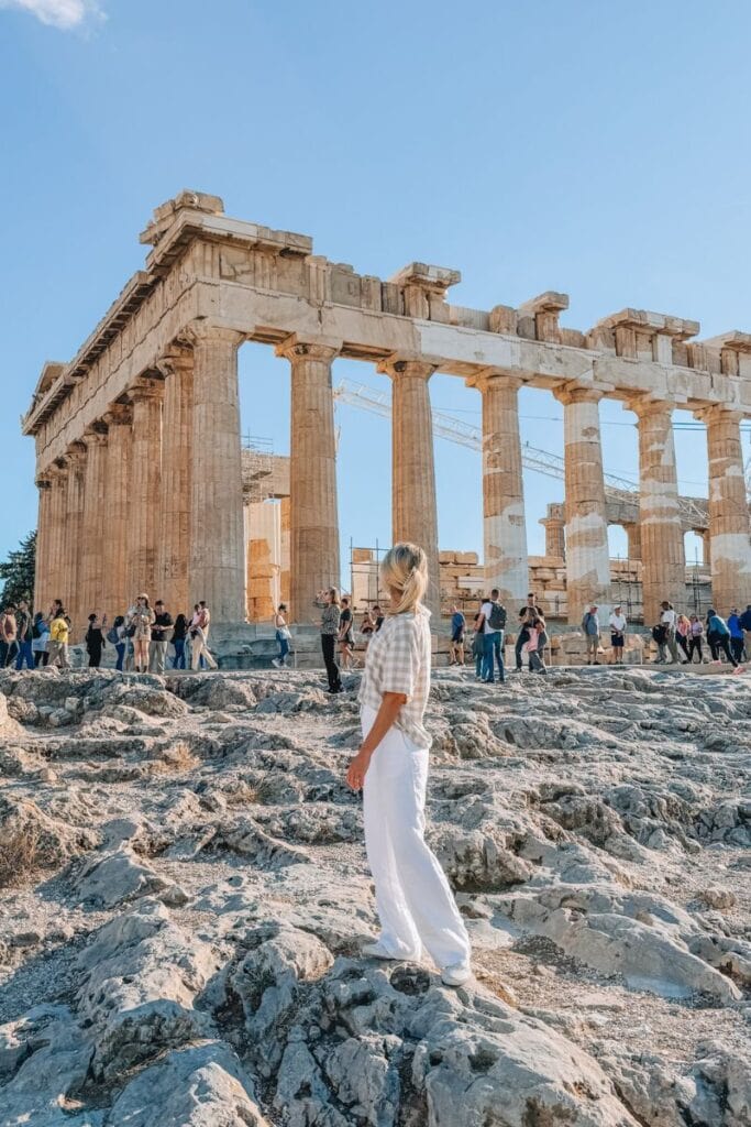 Ancient Greek temple ruins with visitors exploring the historic site in Athens.