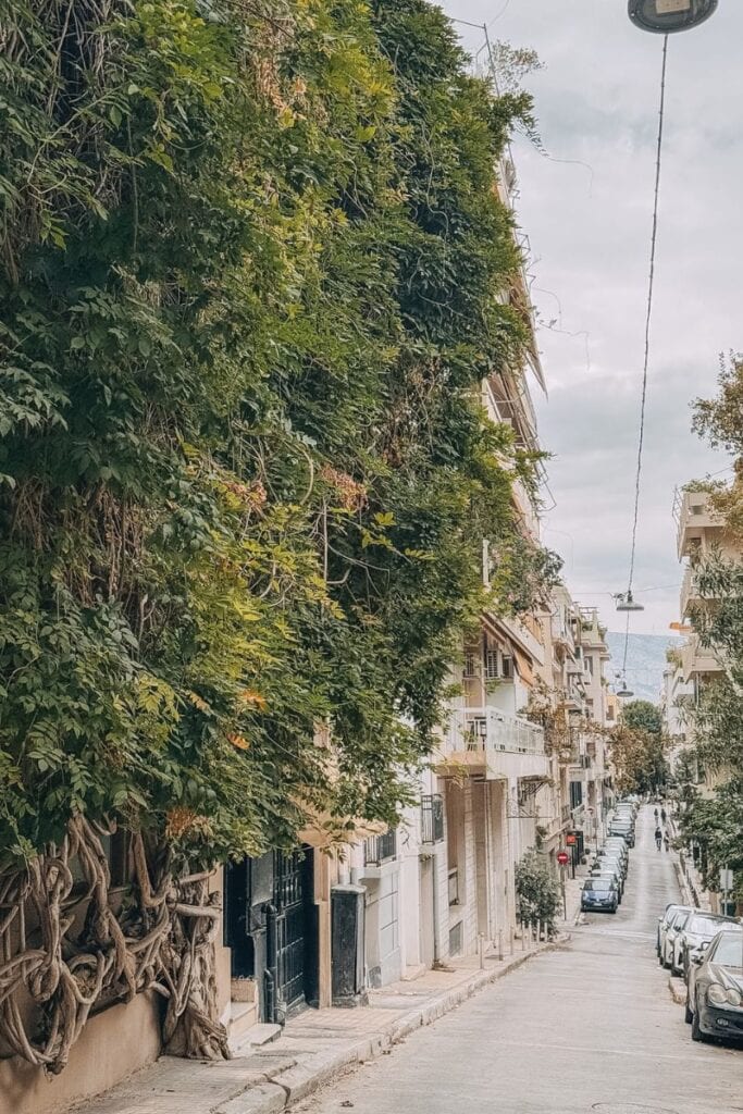 Charming street in Athens with lush trees and historic buildings, perfect for exploring the best are.