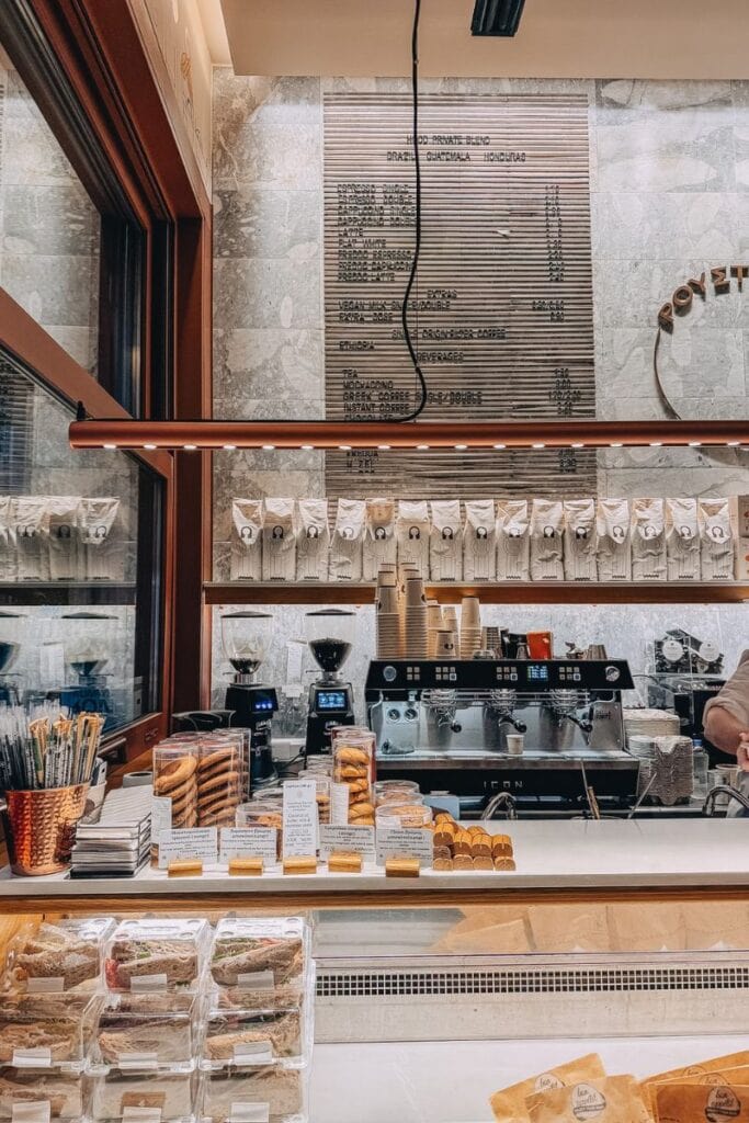 Modern coffee shop interior in Athens with baked goods and coffee equipment.