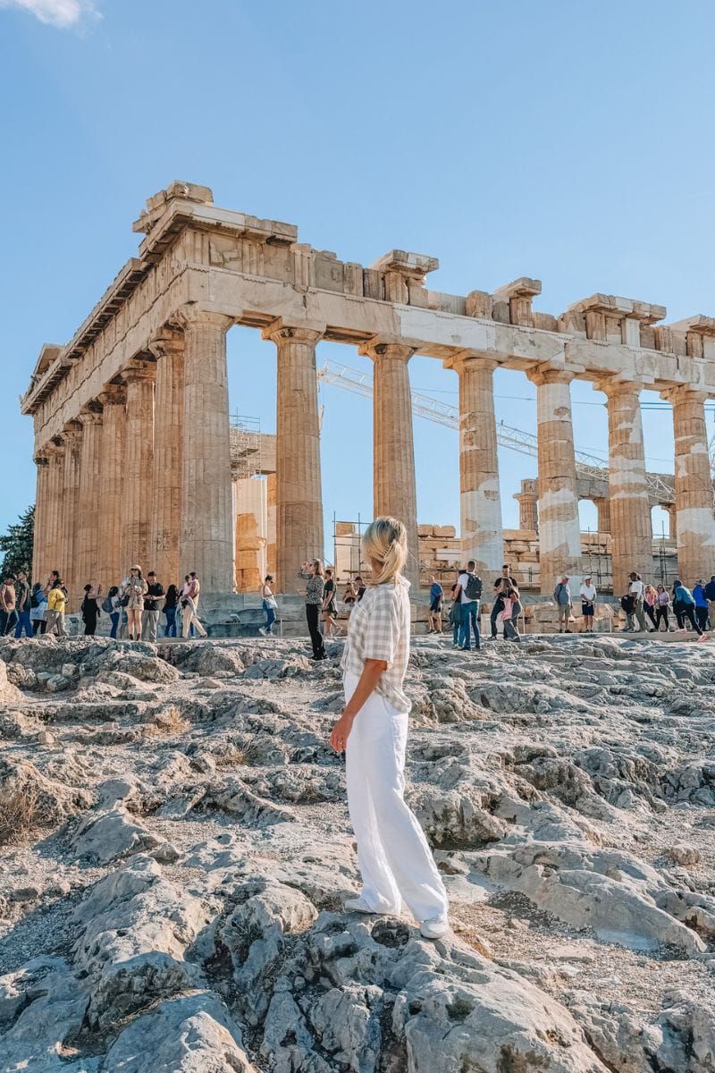 Ancient Greek temple ruins with visitors exploring the historic site in Athens.
