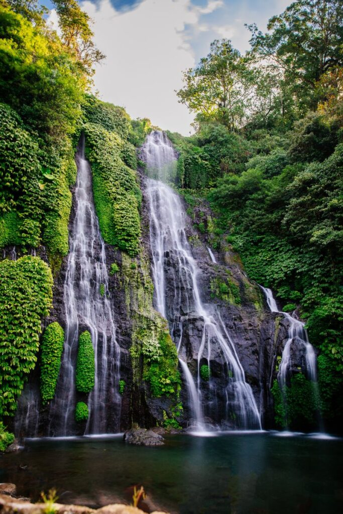 Waterfall surrounded by lush greenery in Munduk, Bali.