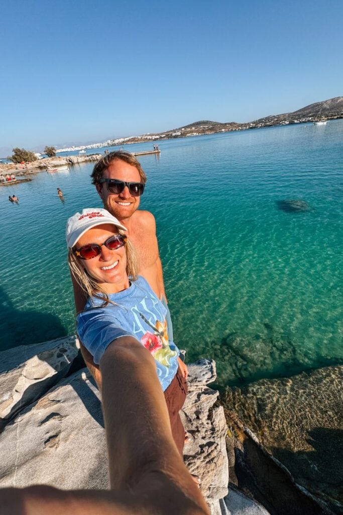 Relaxing couple taking a selfie by the clear blue sea on a sunny day.