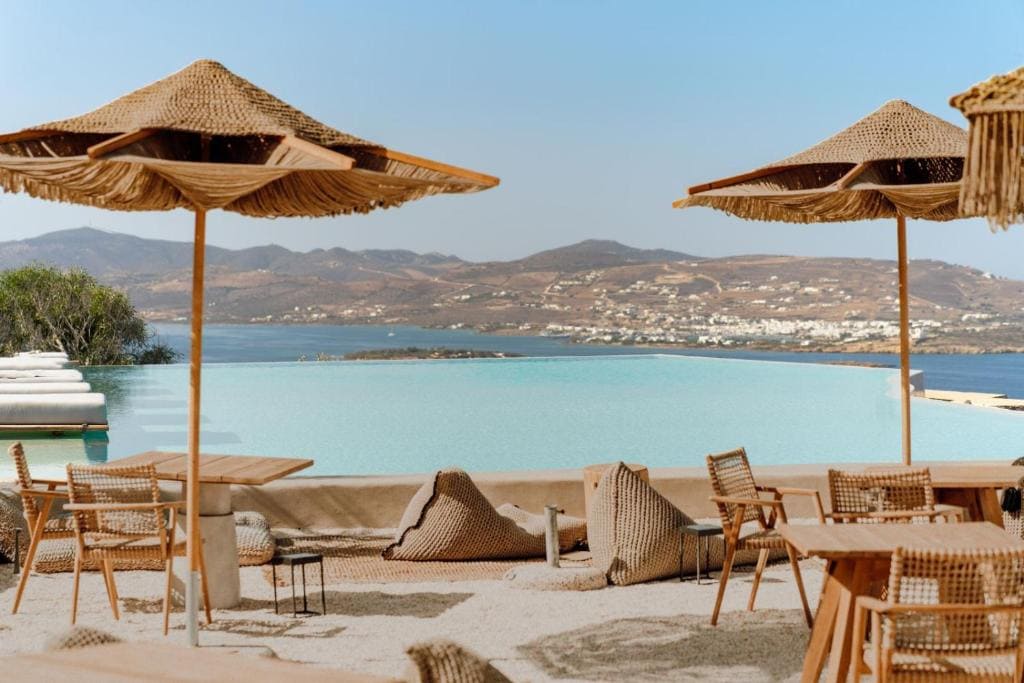 Relaxing poolside view at a Paros hotel with umbrellas and seating overlooking the Aegean Sea.
