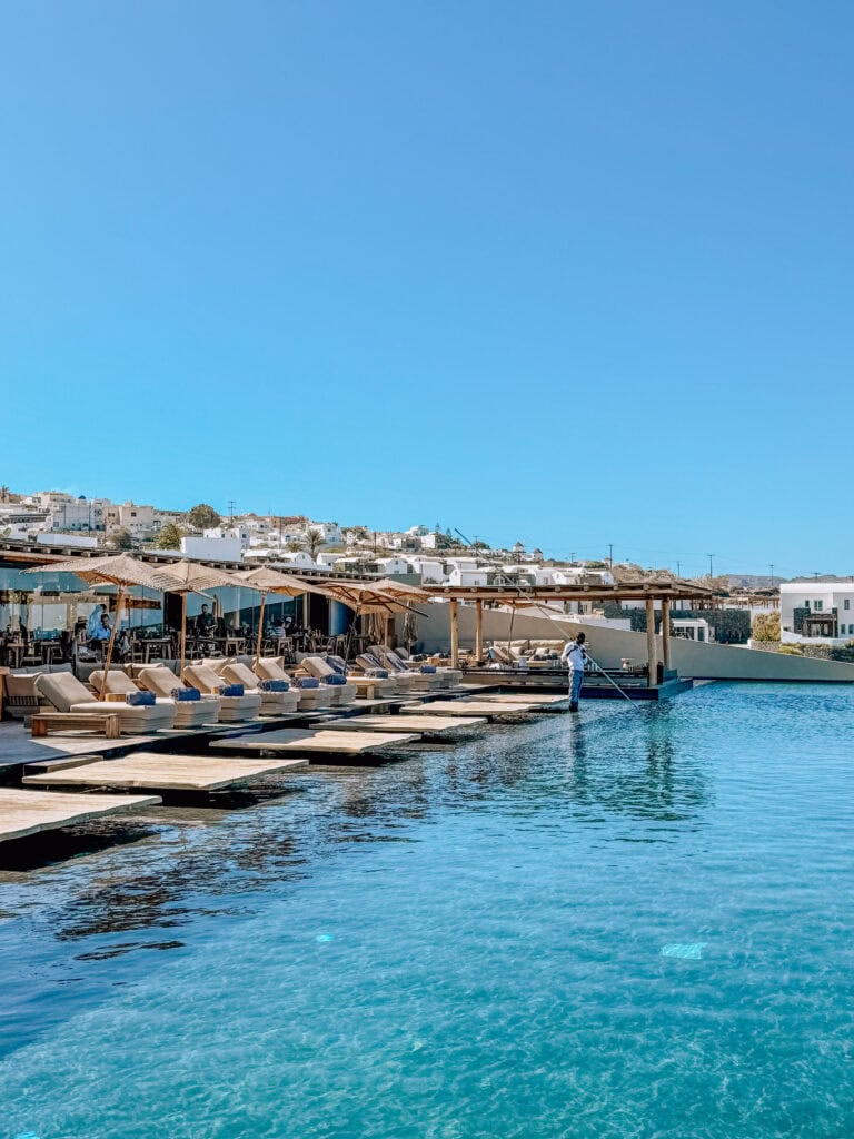 Beautiful waterfront with sun loungers and clear blue water in Greece.
